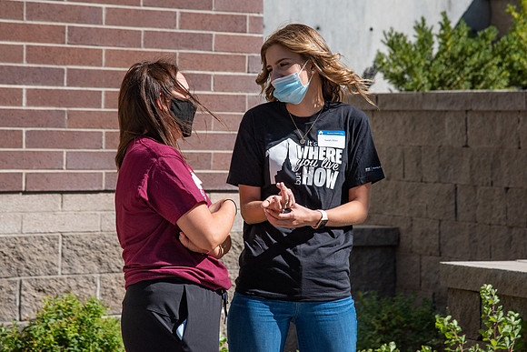 Students with the housing and student living council wearing face masks while out talking to one another.