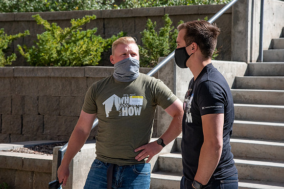 Students with the housing and student living council wearing face masks while out talking to one another.