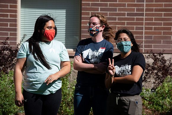 Students with the housing and student living council wearing face masks while out talking to one another.