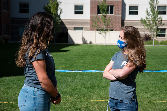 Students with the housing and student living council wearing face masks while out talking to one another.