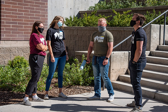 Students with the housing and student living council wearing face masks while out talking to one another.