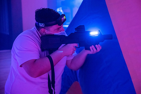 Students play laser tag on campus with masks on.