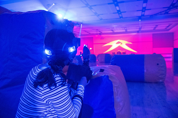 Students play laser tag on campus with masks on.