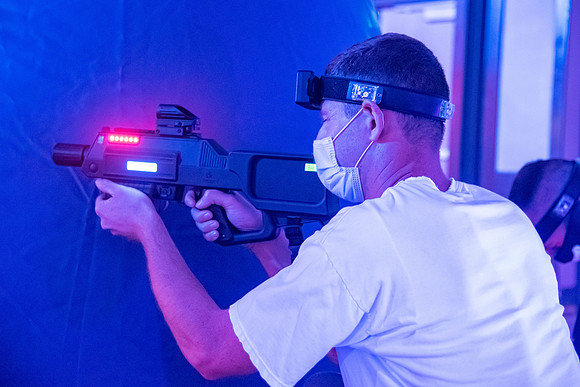 Students play laser tag on campus with masks on.