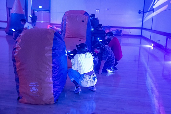 Students play laser tag on campus with masks on.
