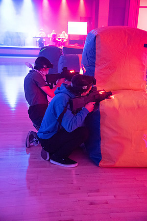 Students play laser tag on campus with masks on.