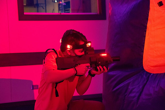 Students play laser tag on campus with masks on.