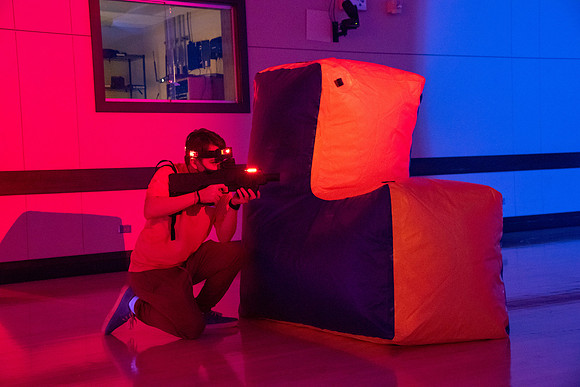 Students play laser tag on campus with masks on.