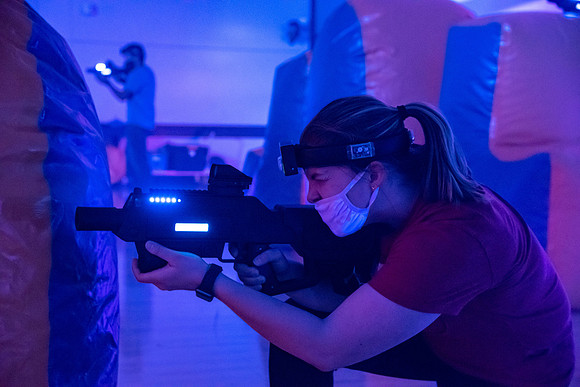 Students play laser tag on campus with masks on.