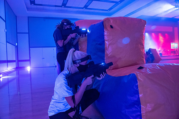 Students play laser tag on campus with masks on.
