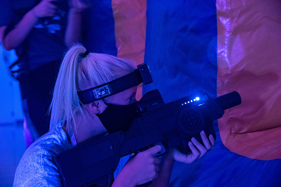 Students play laser tag on campus with masks on.