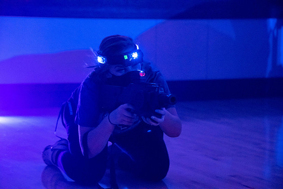 Students play laser tag on campus with masks on.
