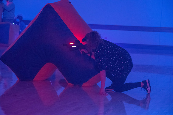 Students play laser tag on campus with masks on.
