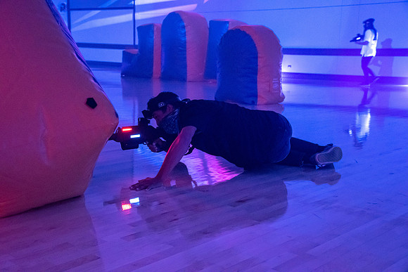 Students play laser tag on campus with masks on.
