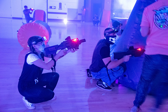 Students play laser tag on campus with masks on.