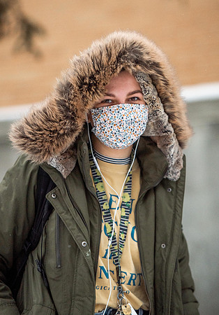 Students smiling with masks around campus on a snowy afternoon at BYUI during the Covid pandemic.