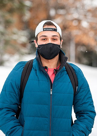 Students smiling with masks around campus on a snowy afternoon at BYUI during the Covid pandemic.