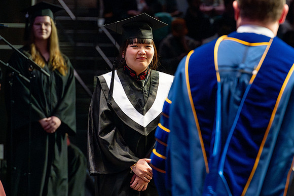 Graduates walk across the stage.