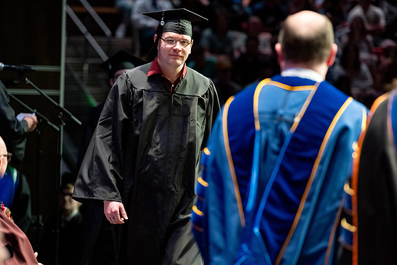 Graduates walk across the stage.