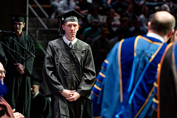 Graduates walk across the stage.