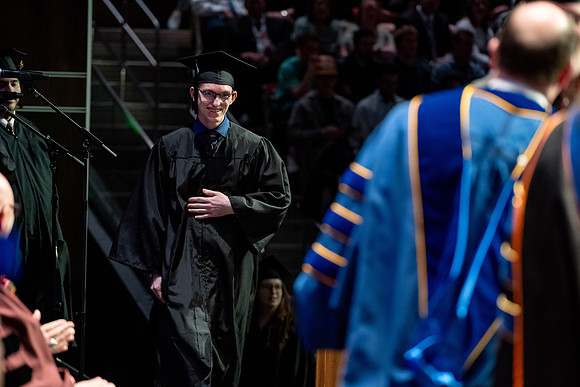 Graduates walk across the stage.