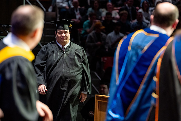 Graduates walk across the stage.