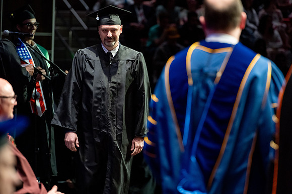 Graduates walk across the stage.