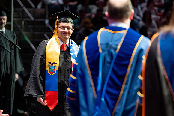 Graduates walk across the stage.