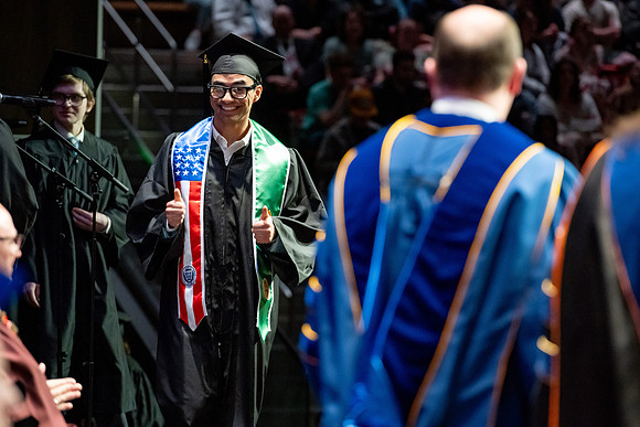 Graduates walk across the stage.