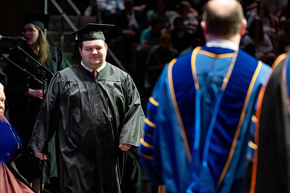 Graduates walk across the stage.