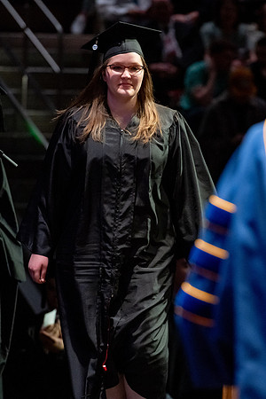 Graduates walk across the stage.