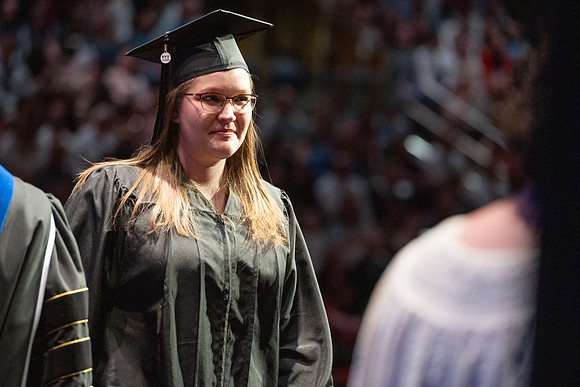 Graduates walk across the stage.