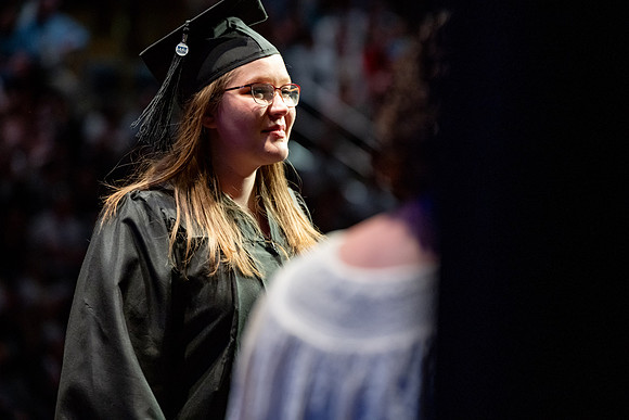 Graduates walk across the stage.