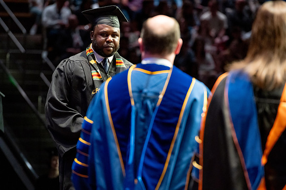 Graduates walk across the stage.