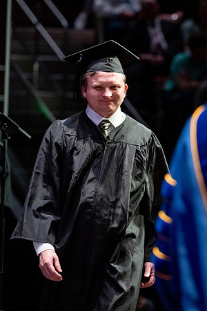 Graduates walk across the stage.