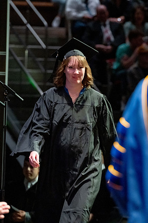 Graduates walk across the stage.