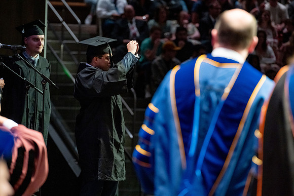 Graduates walk across the stage.