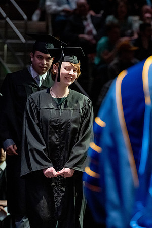 Graduates walk across the stage.