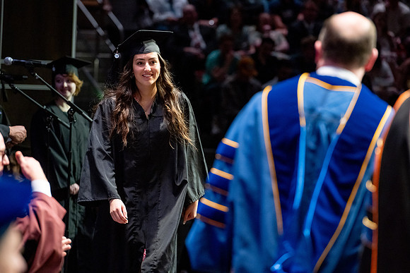 Graduates walk across the stage.