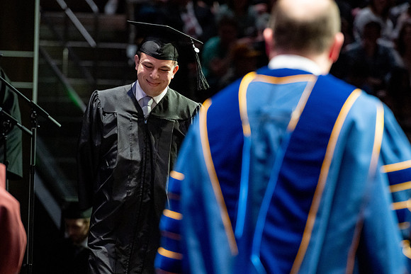 Graduates walk across the stage.