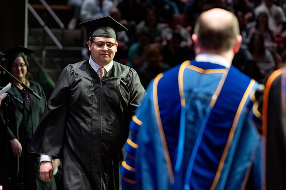 Graduates walk across the stage.