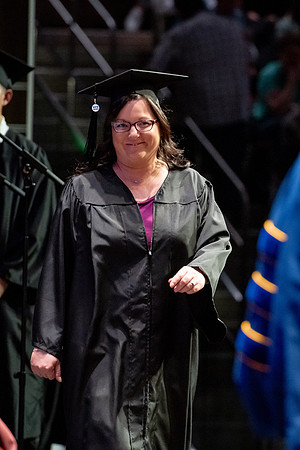 Graduates walk across the stage.