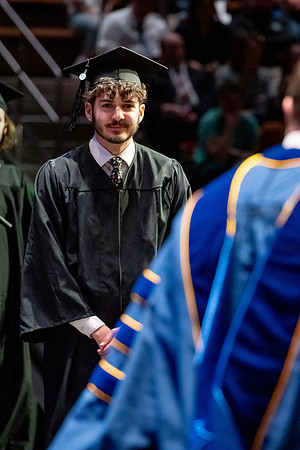 Graduates walk across the stage.
