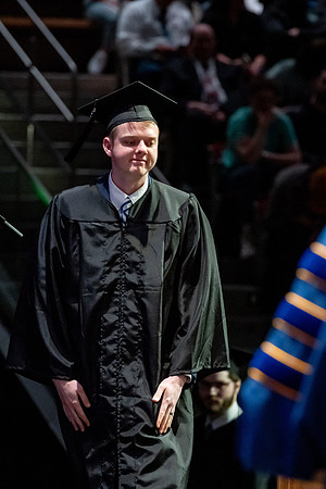 Graduates walk across the stage.