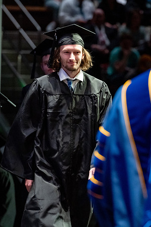 Graduates walk across the stage.