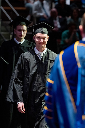 Graduates walk across the stage.