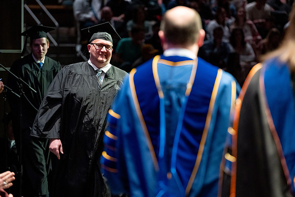 Graduates walk across the stage.