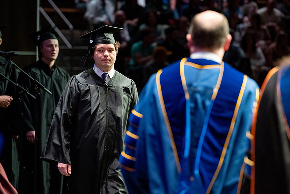 Graduates walk across the stage.