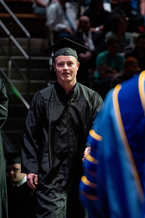 Graduates walk across the stage.
