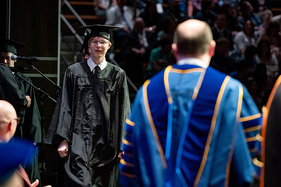 Graduates walk across the stage.